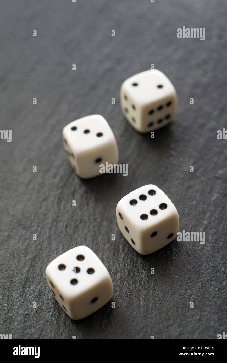 Vier weiße Würfel auf schwarzem Hintergrund Stockfoto