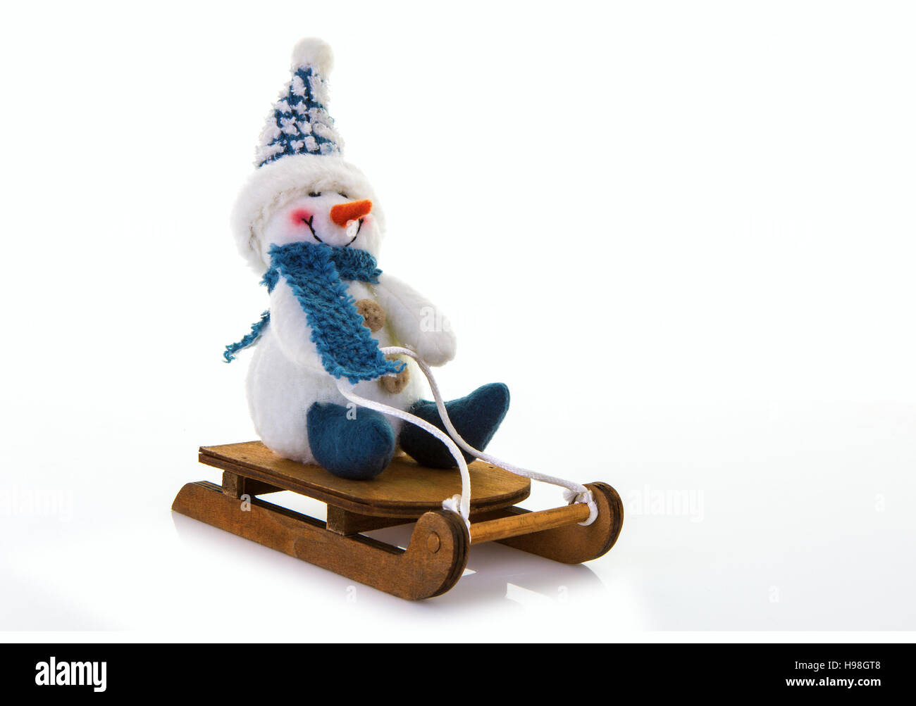 Schneemann auf einem Schlitten auf weißem Hintergrund. Stockfoto