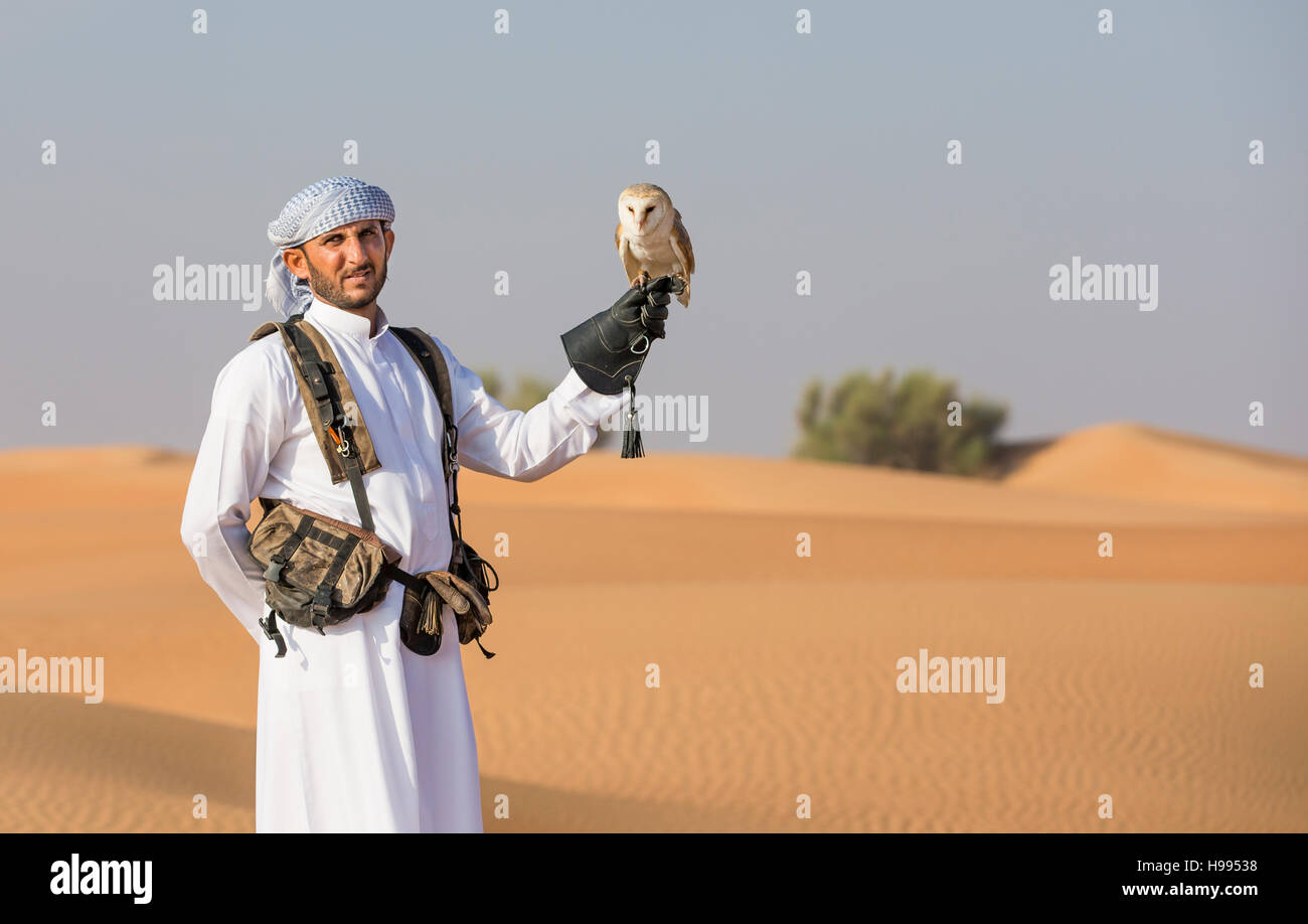 Dubai, Vereinigte Arabische Emirate, 19. November 2016: Ein Falkner in traditioneller Kleidung, Ausbildung eine Schleiereule (Tyto Alba) Stockfoto