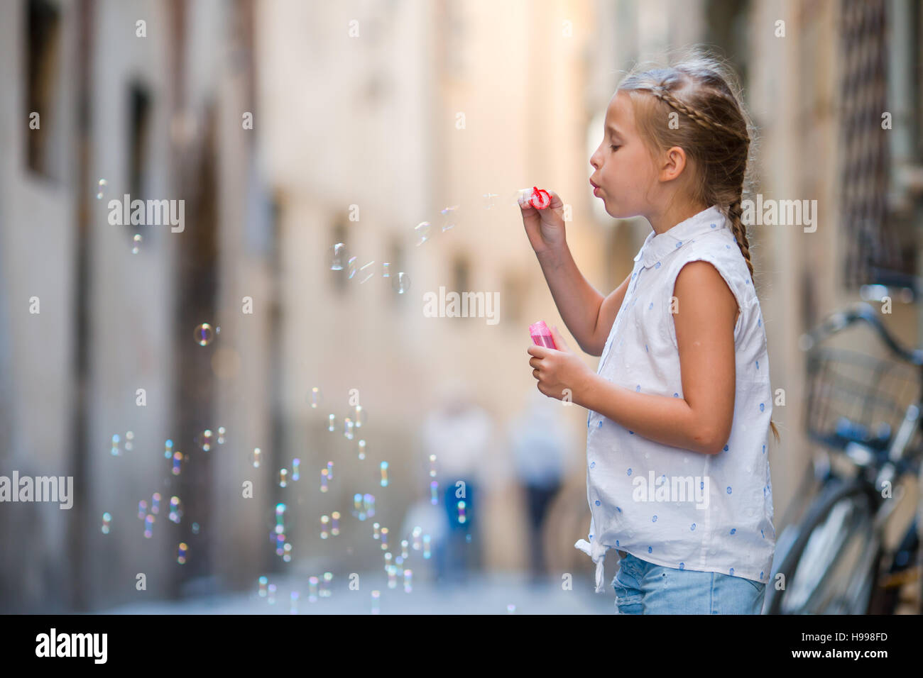 Entzückende kleine Mädchen im freien Seifenblasen in europäischen Städten. Porträt des kaukasischen Kind genießen Sommerurlaub in Italien Stockfoto