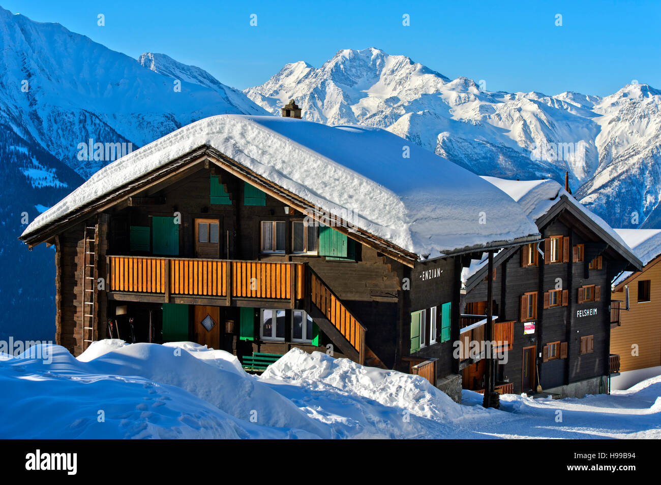 Schweizer Chalet mit dicken Schneedecke auf dem Dach gegen den Gipfel Fletschhorn, Bettmeralp, Wallis, Schweiz Stockfoto