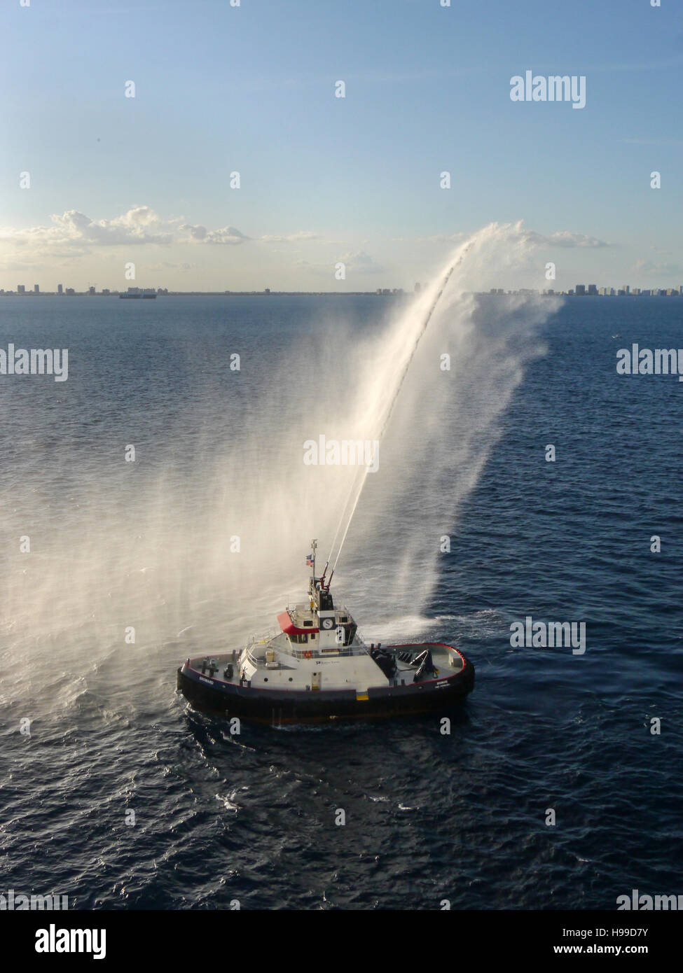 Ein Lotsenboot tun einen Wasser-Gruß für die Ankunft einer neuen Kreuzfahrt Schiff vor der Küste von Fort Lauderdale Stockfoto