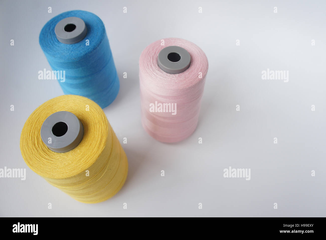 3-Faden-Spulen, blau, rosa und gelb, Medium hautnah Stockfoto