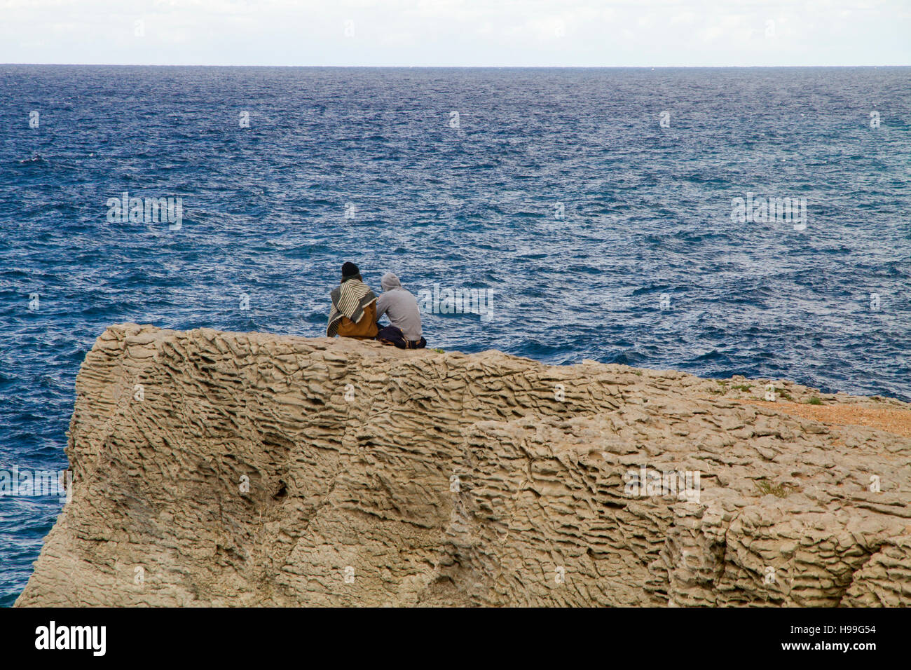 Junges Paar sitzt oben auf einem Felsen genießen Sie eine herrliche Aussicht auf das Meer Landschaft Banyalbufar Mallorca Stockfoto