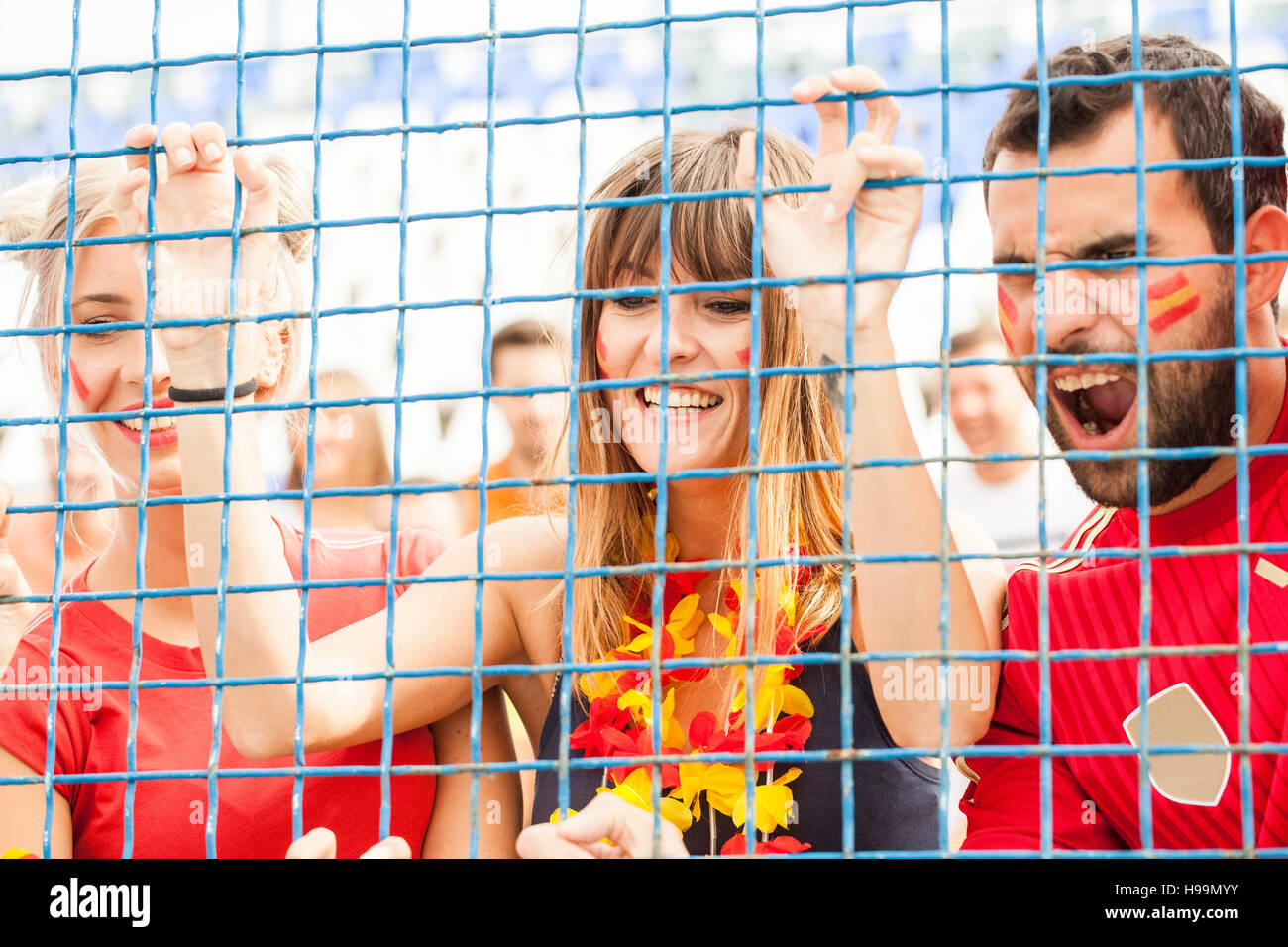 Gruppe von Fußball-Fans hinter Zaun im Stadion Stockfoto