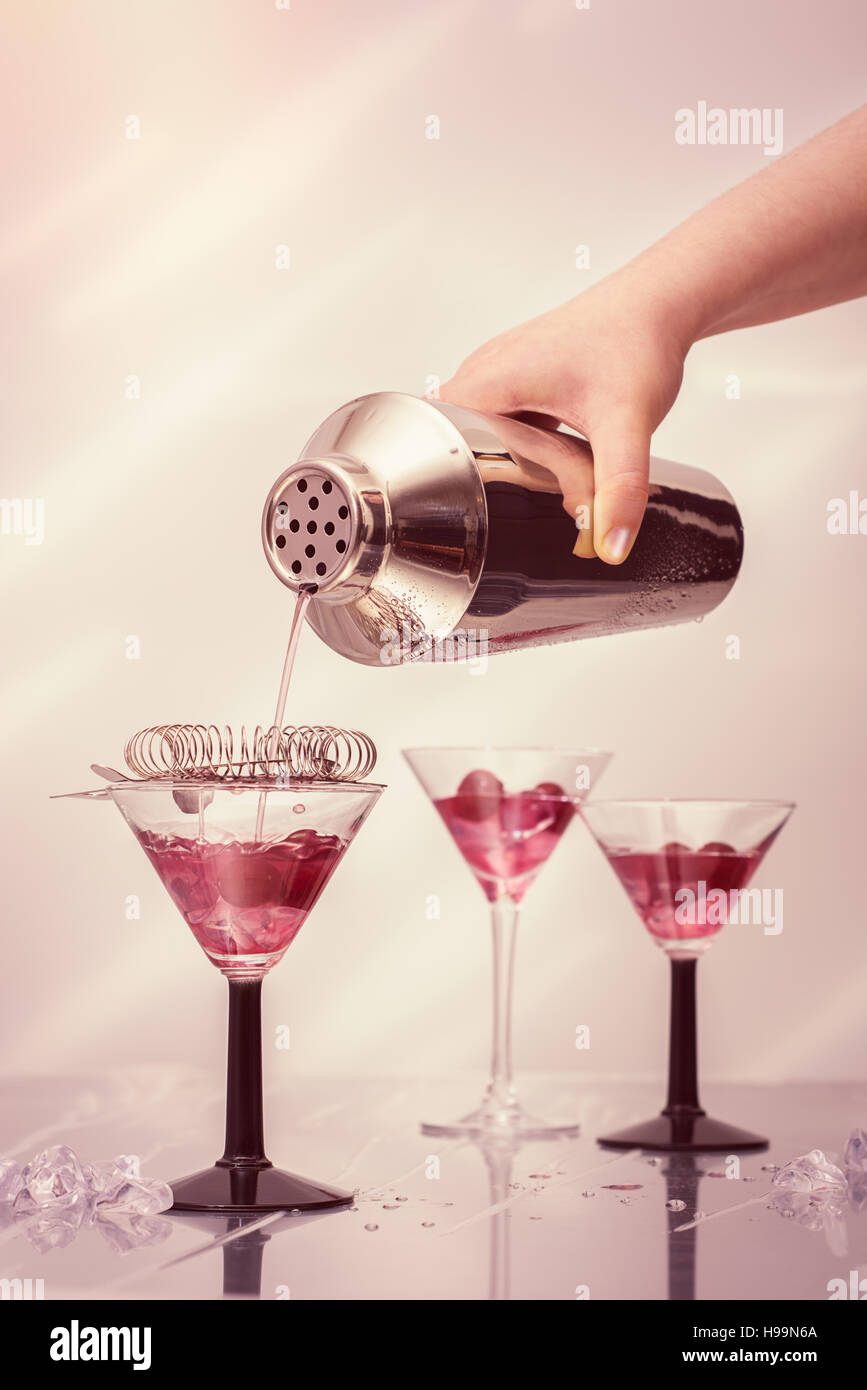 Cocktails aus einem Shaker Gießen in Art-Deco-cocktail-Gläser Stockfoto