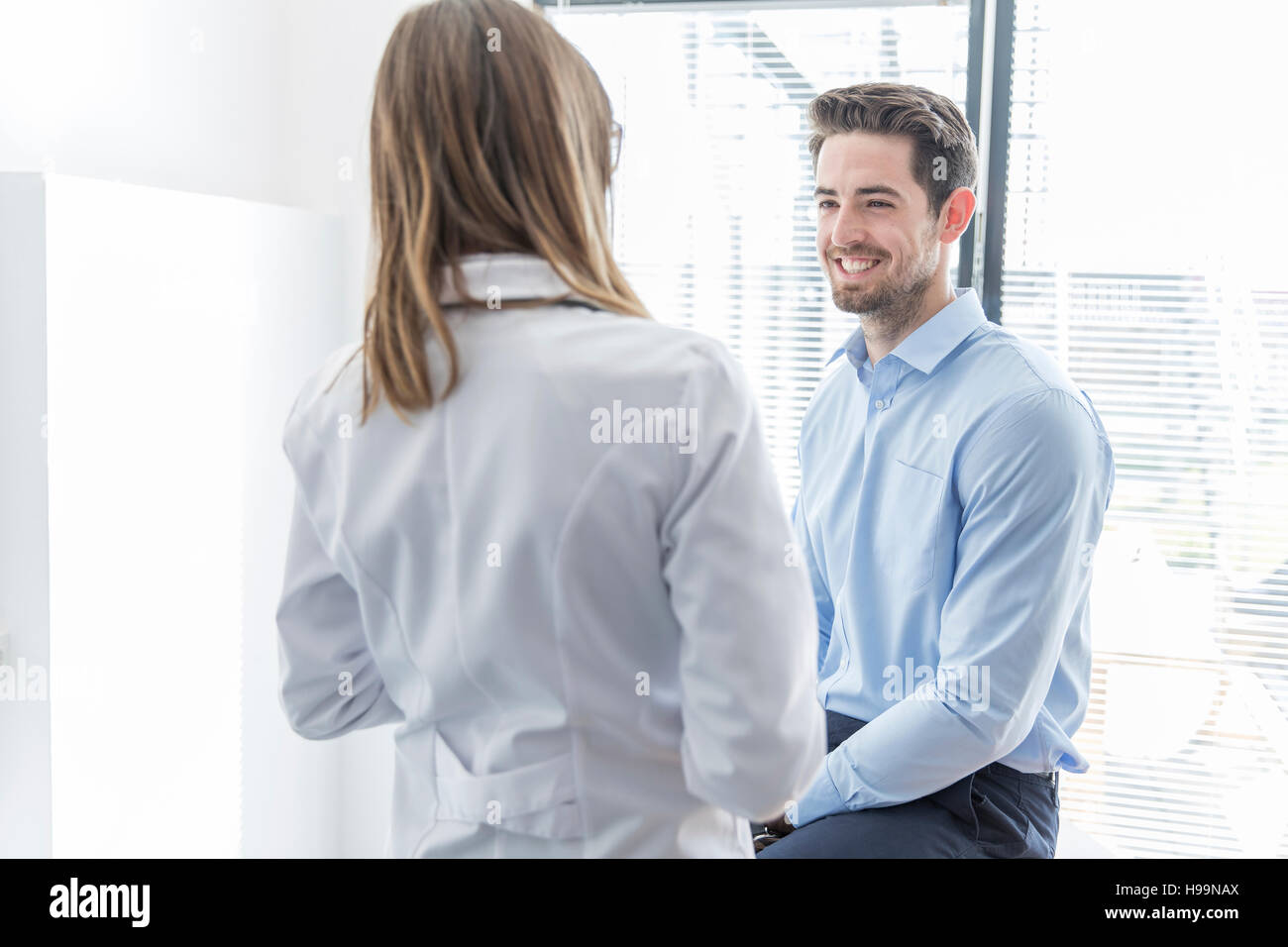 Ärztin im Gespräch mit männlichen Patienten im Krankenhaus Stockfoto