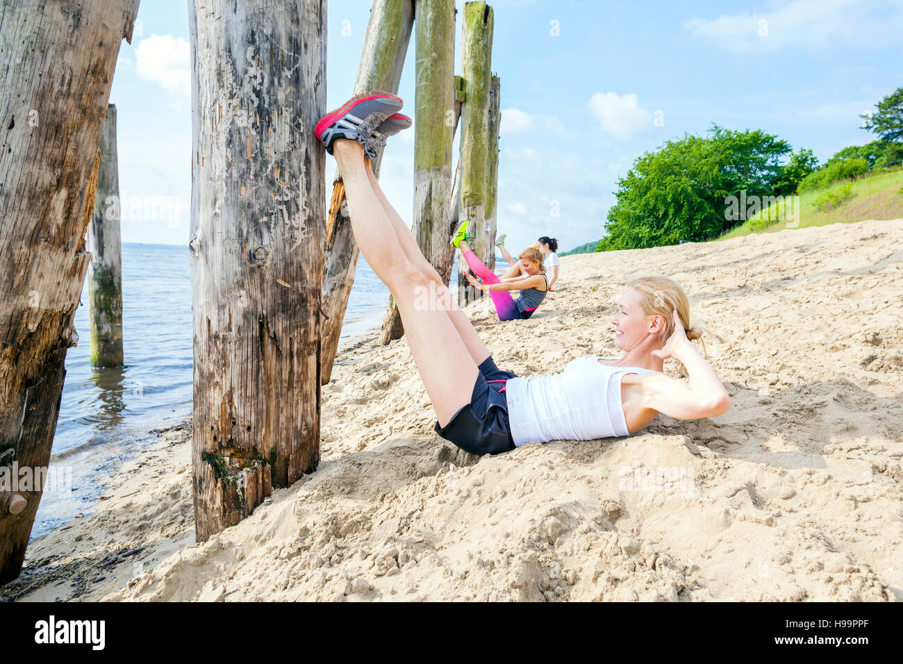 Junge Frauen am Strand Sit Stockfoto