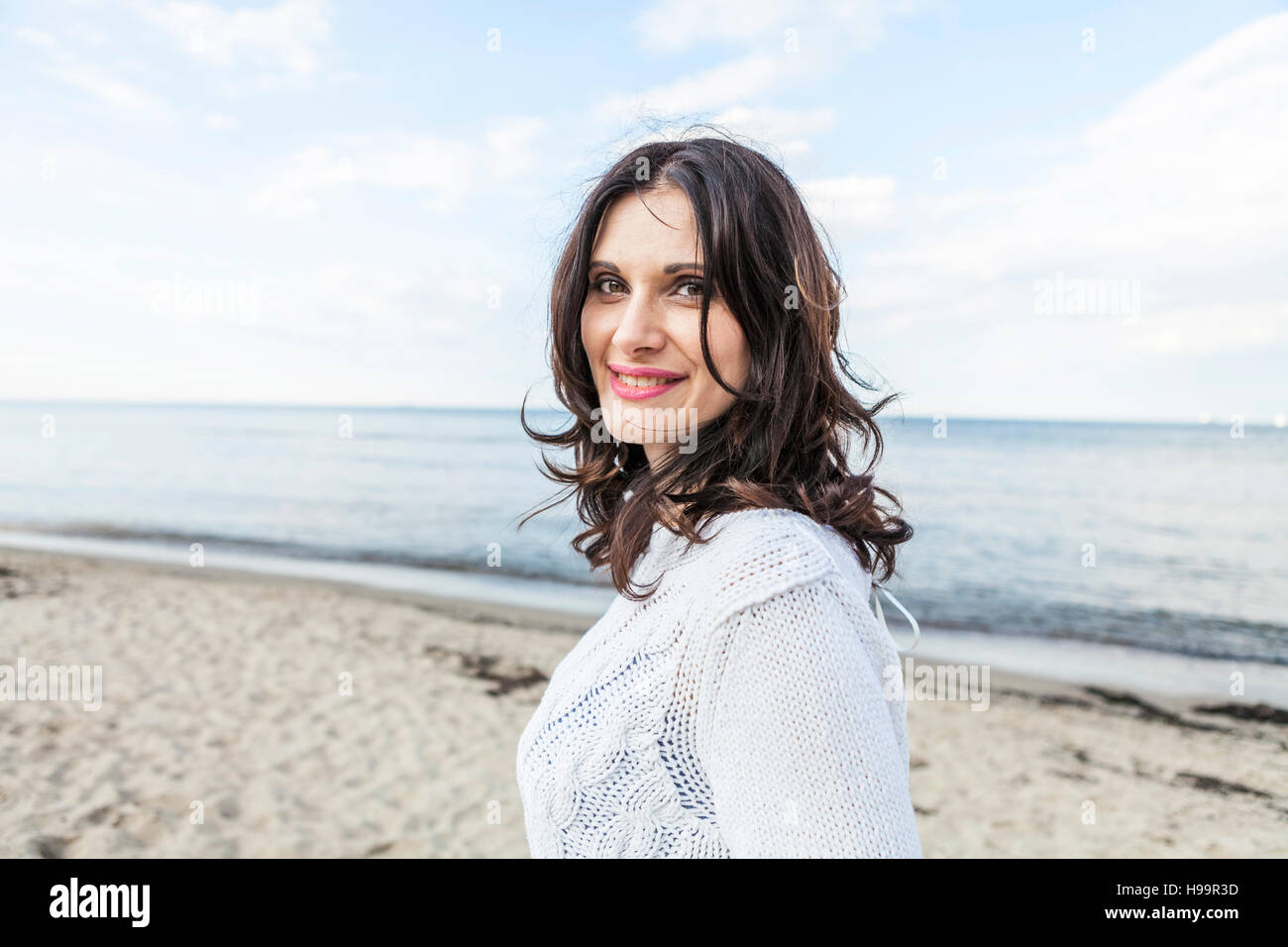 Porträt Frau mit braunen Haaren am Strand Stockfoto