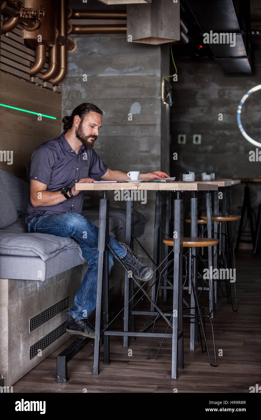 Mann im Café lesen Zeitung Stockfoto