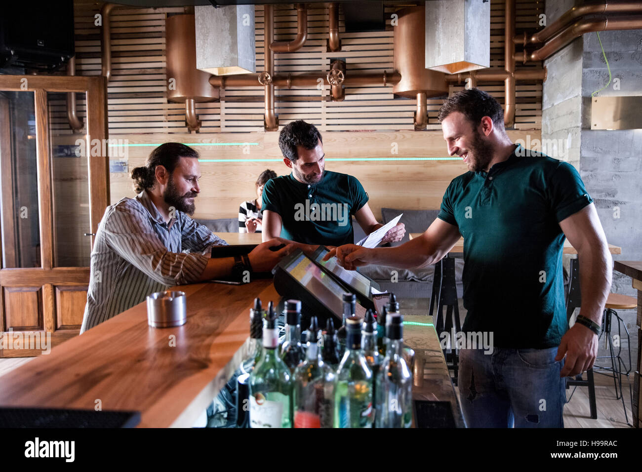 Barkeeper und männliche Gäste im Café Stockfoto
