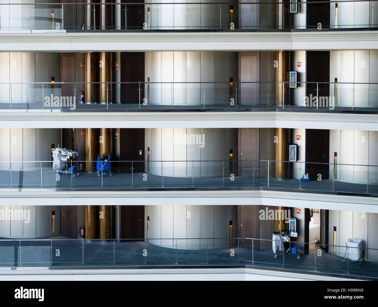 Die Reinigung Kader eines großen Businesshotels reinigt die Etagen und Zimmer. Viele Zimmer auf vielen Ebenen sichtbar. Stockfoto