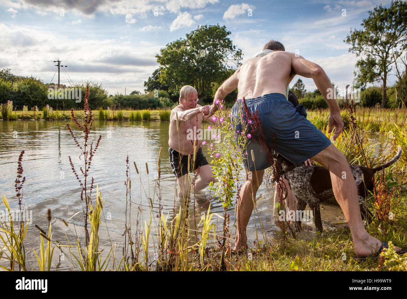 Älterer Mann geholfen vom See nach dem Schwimmen Stockfoto