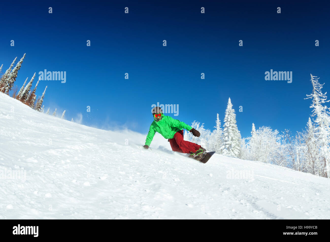 Snowboarder reitet auf Piste Snowboard Stockfoto