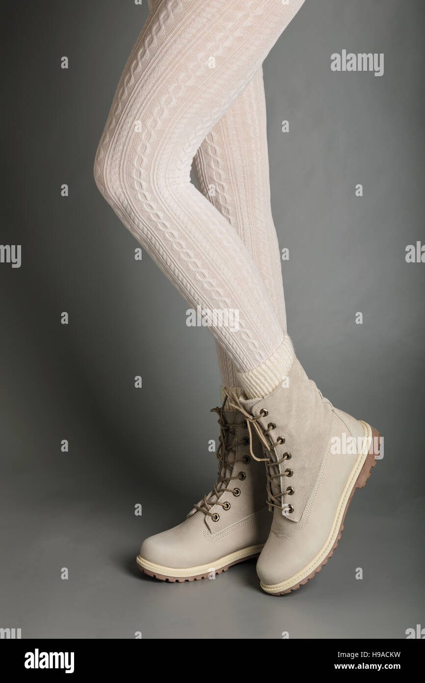 Weibliche Beine in weißen Strumpfhosen und helle winter Stiefel. Stockfoto