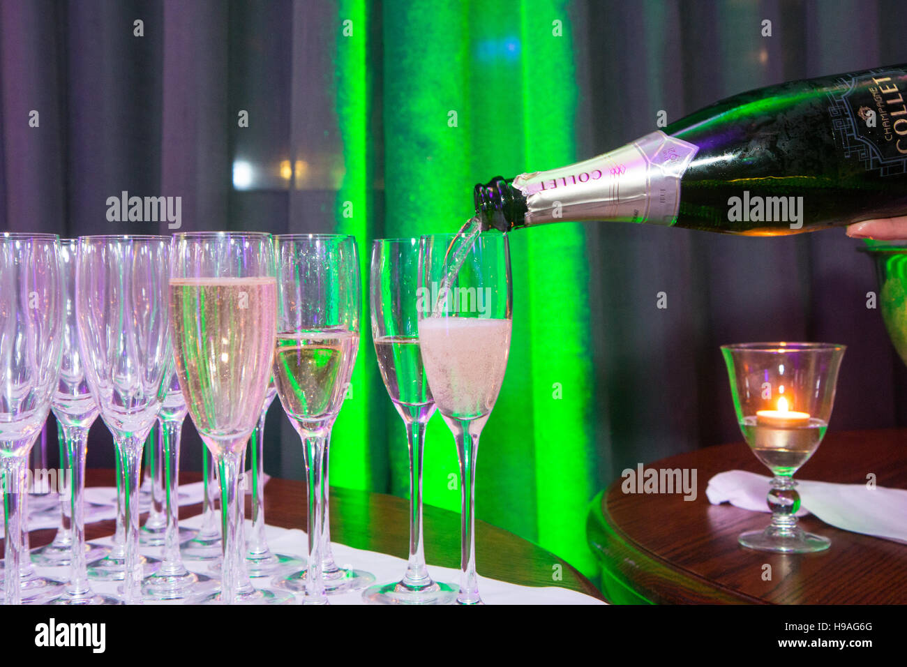 Champagner wird in Gläser gegossen Stockfoto