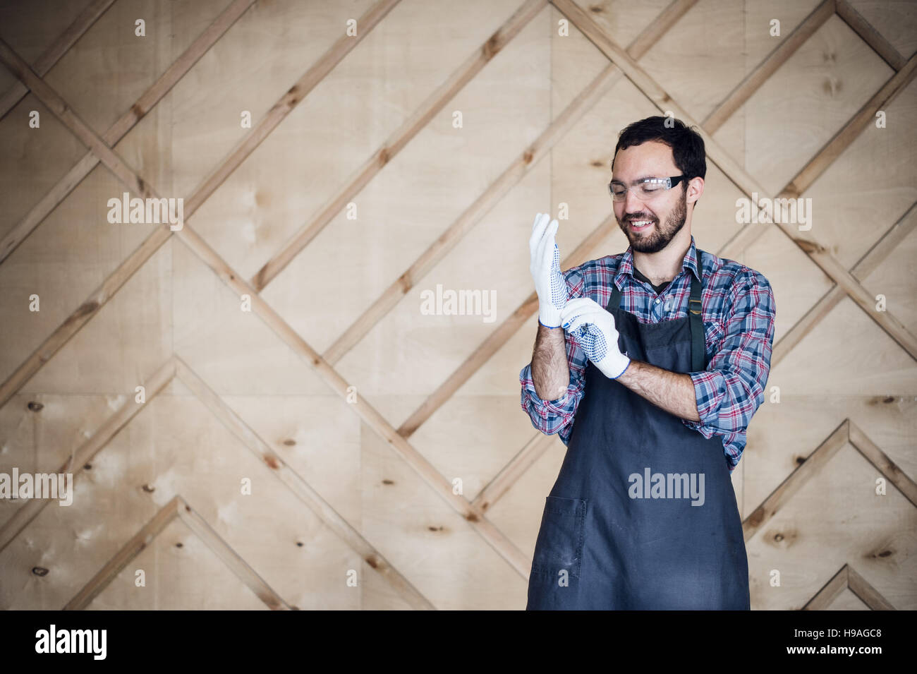 Porträt eines Zimmermanns in Werkstatt mit Handschuhen Stockfoto