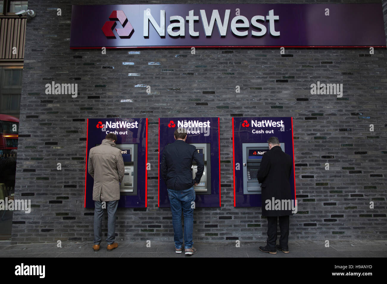 Drei Männer machen eine Barentnahme bei NatWest Banken Bargeld Verzicht auf Maschinen, Victoria Street, Central London, England, UK Stockfoto