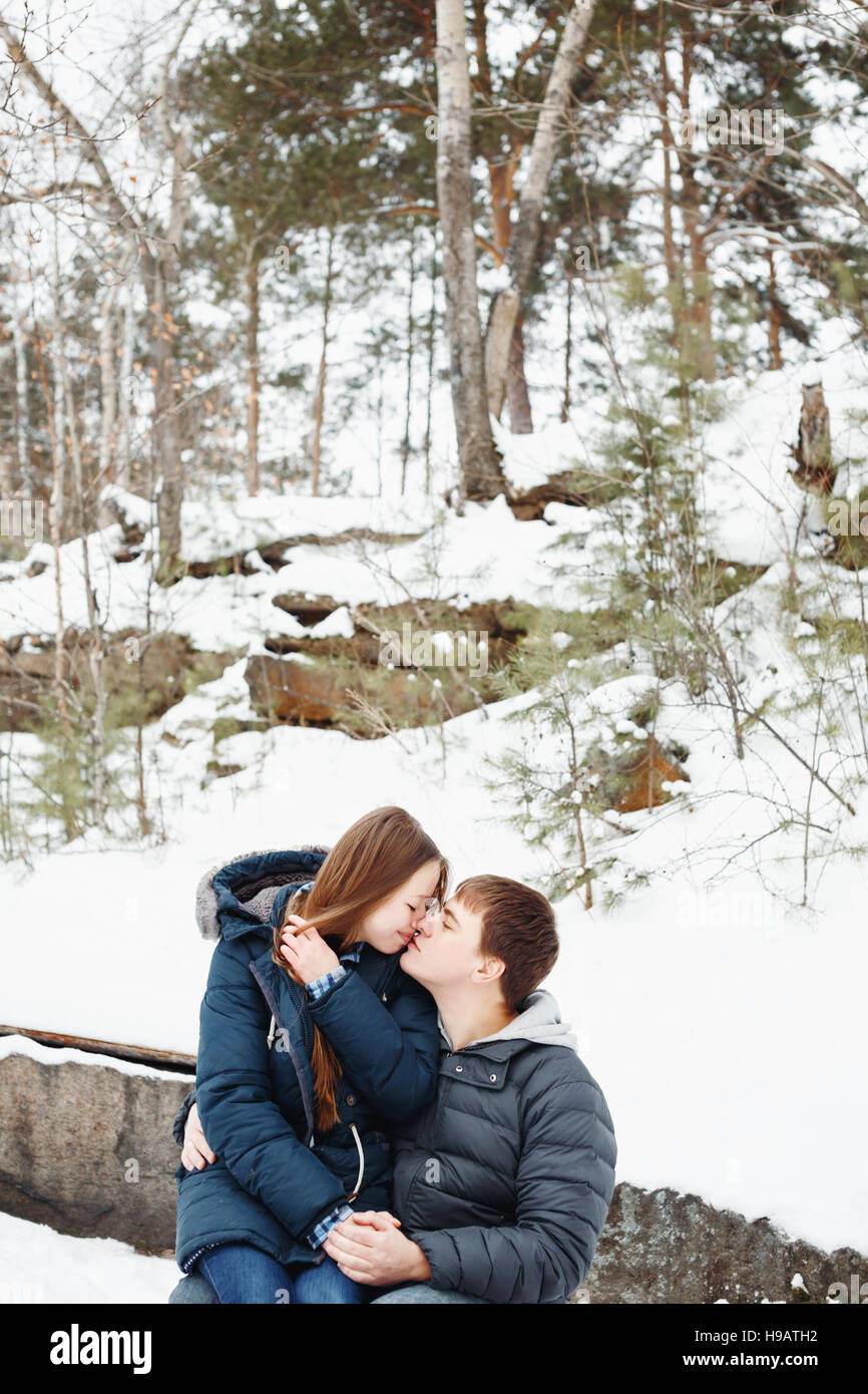 Paar in Liebe küssen im Freien, Winterwald im Hintergrund Stockfoto