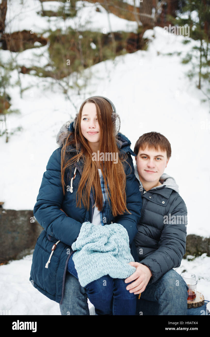 Liebende Paar Spaß im Freien in ländlichen Winterwochenende, Frau sitzt am Knie des Mannes Stockfoto