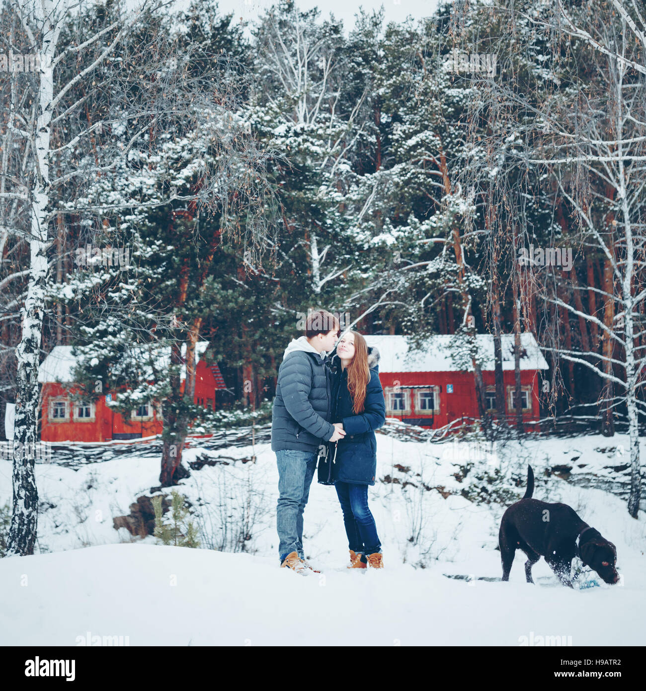 Junge liebende Paare, die Spaß im Winterwald, Winter Urlaub Konzept, getönt Stockfoto