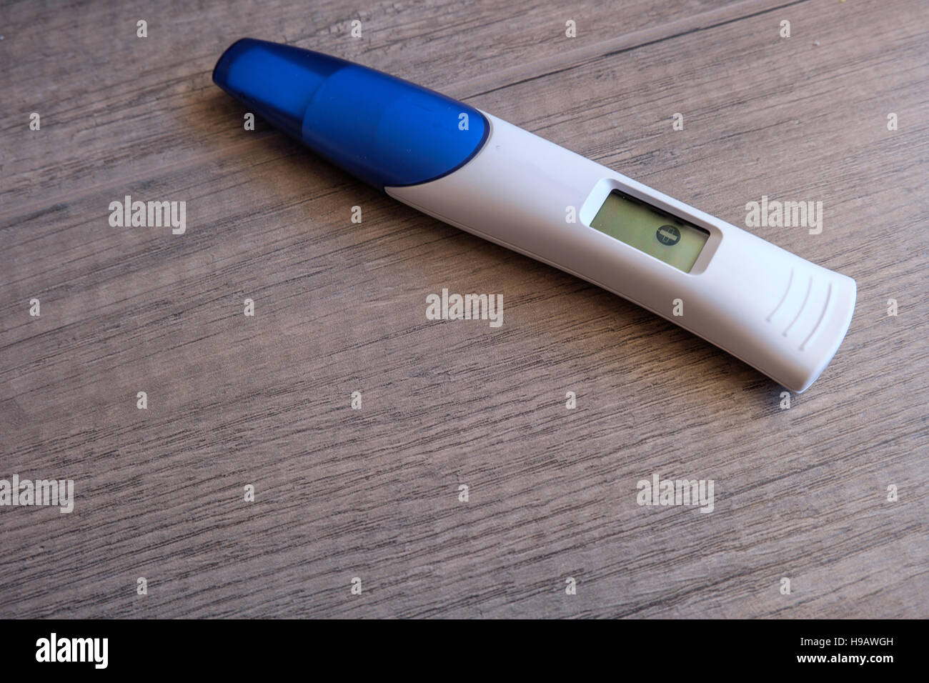 Digitaler Schwangerschaftstest mit negativem Ergebnis auf hölzernen Hintergrund Stockfoto
