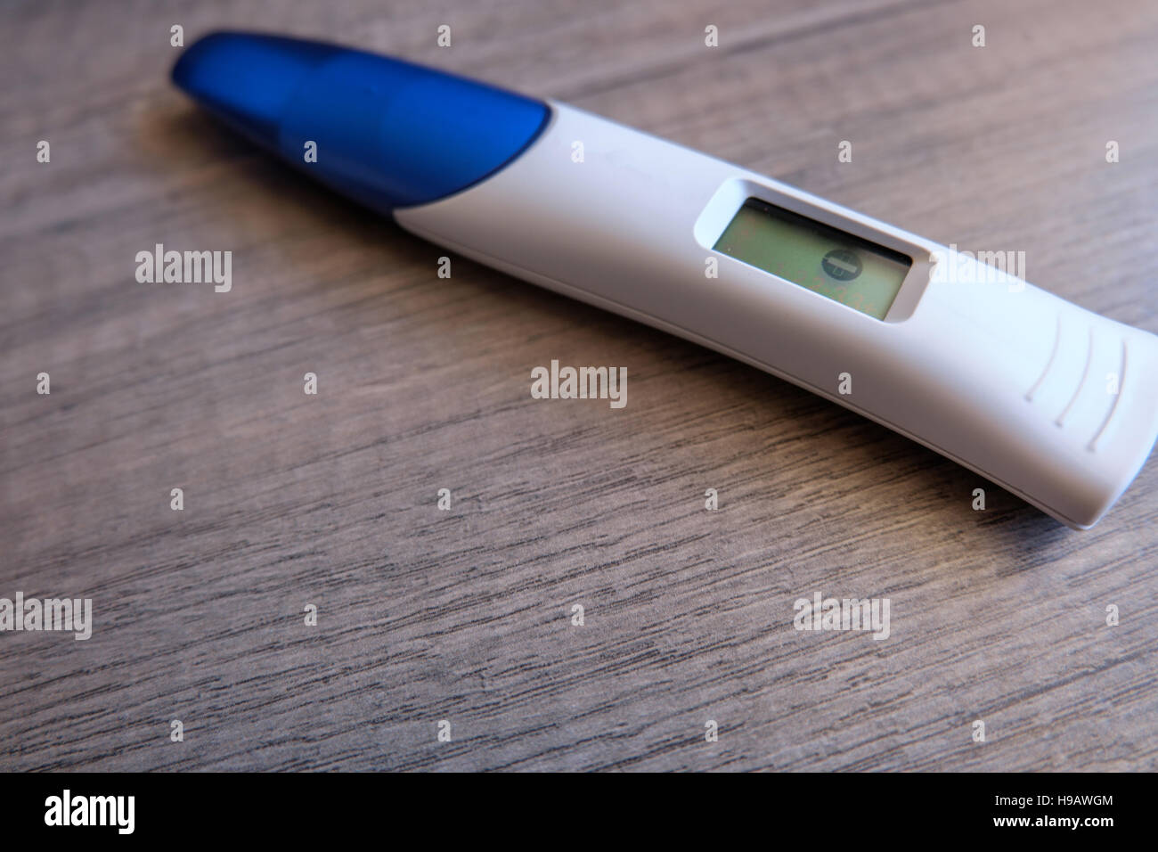 Digitaler Schwangerschaftstest mit negativem Ergebnis auf hölzernen Hintergrund Stockfoto