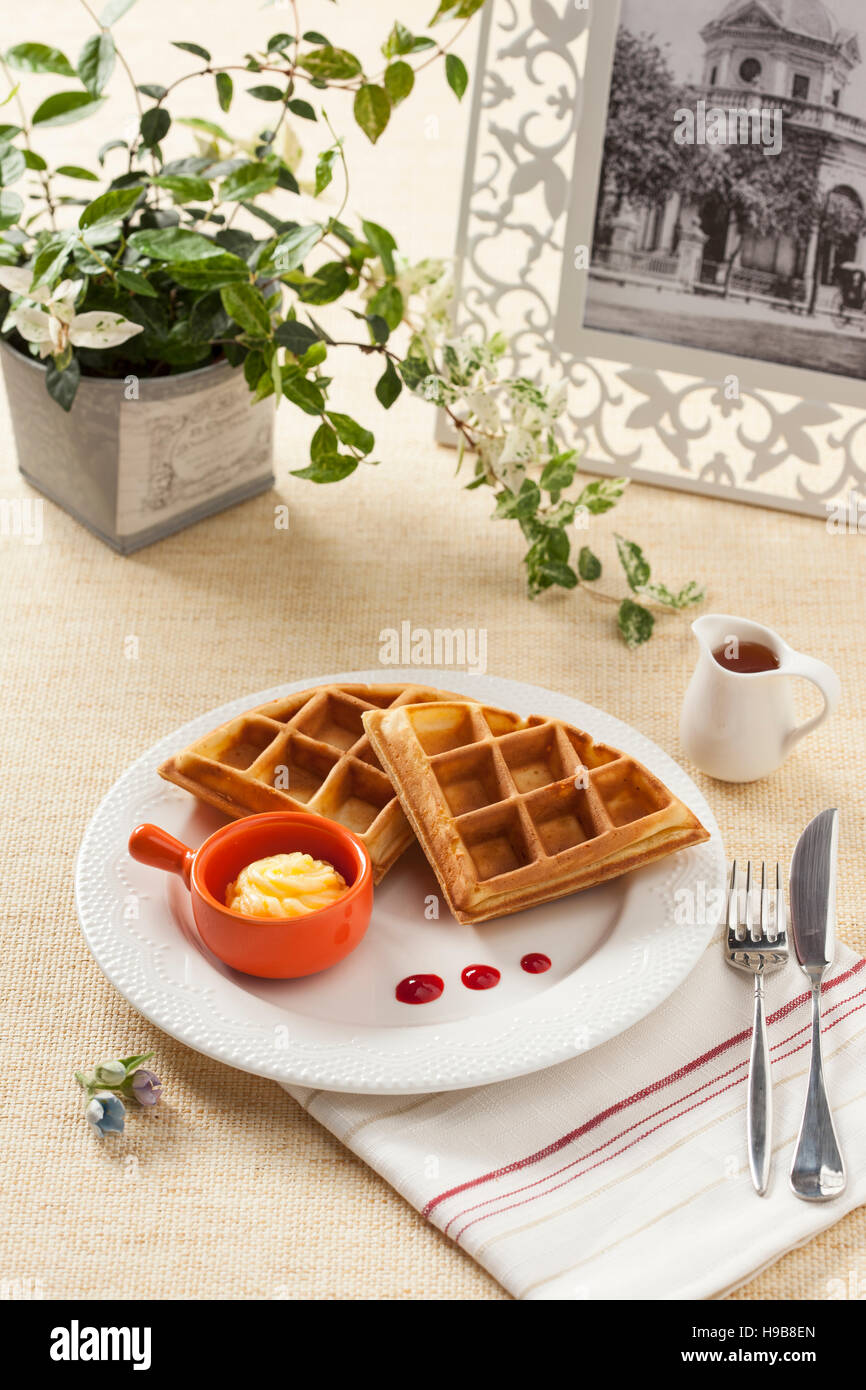 Frühstück-Waffel mit Butter und Sirup mit Blumen- und Foto Rahmen Stockfoto