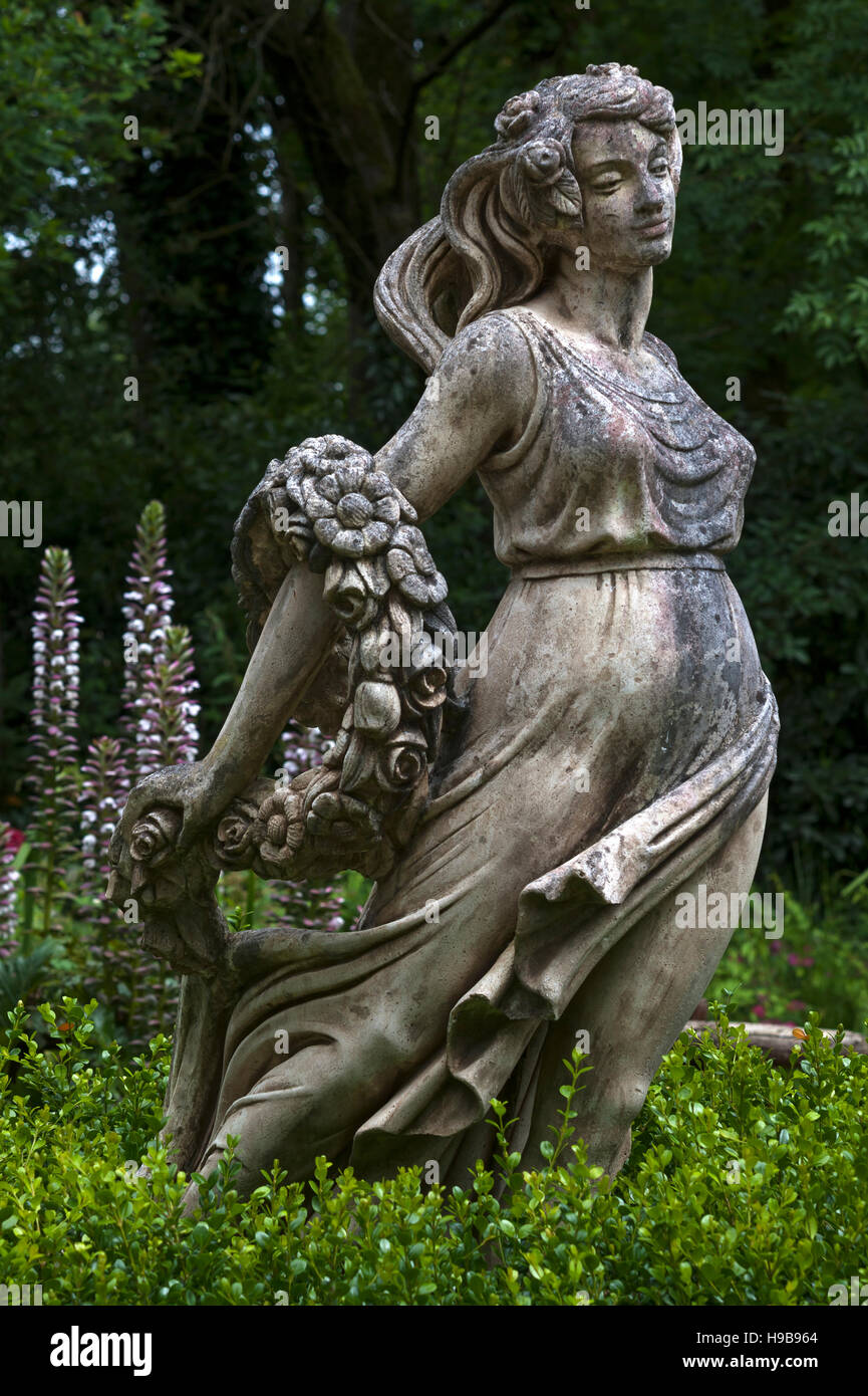 Weibliche Skulptur mit einer Bandbreite von Blumen hinter Akanthus (Acanthus), Parc Floral et tropischen De La Court d'Aron Stockfoto