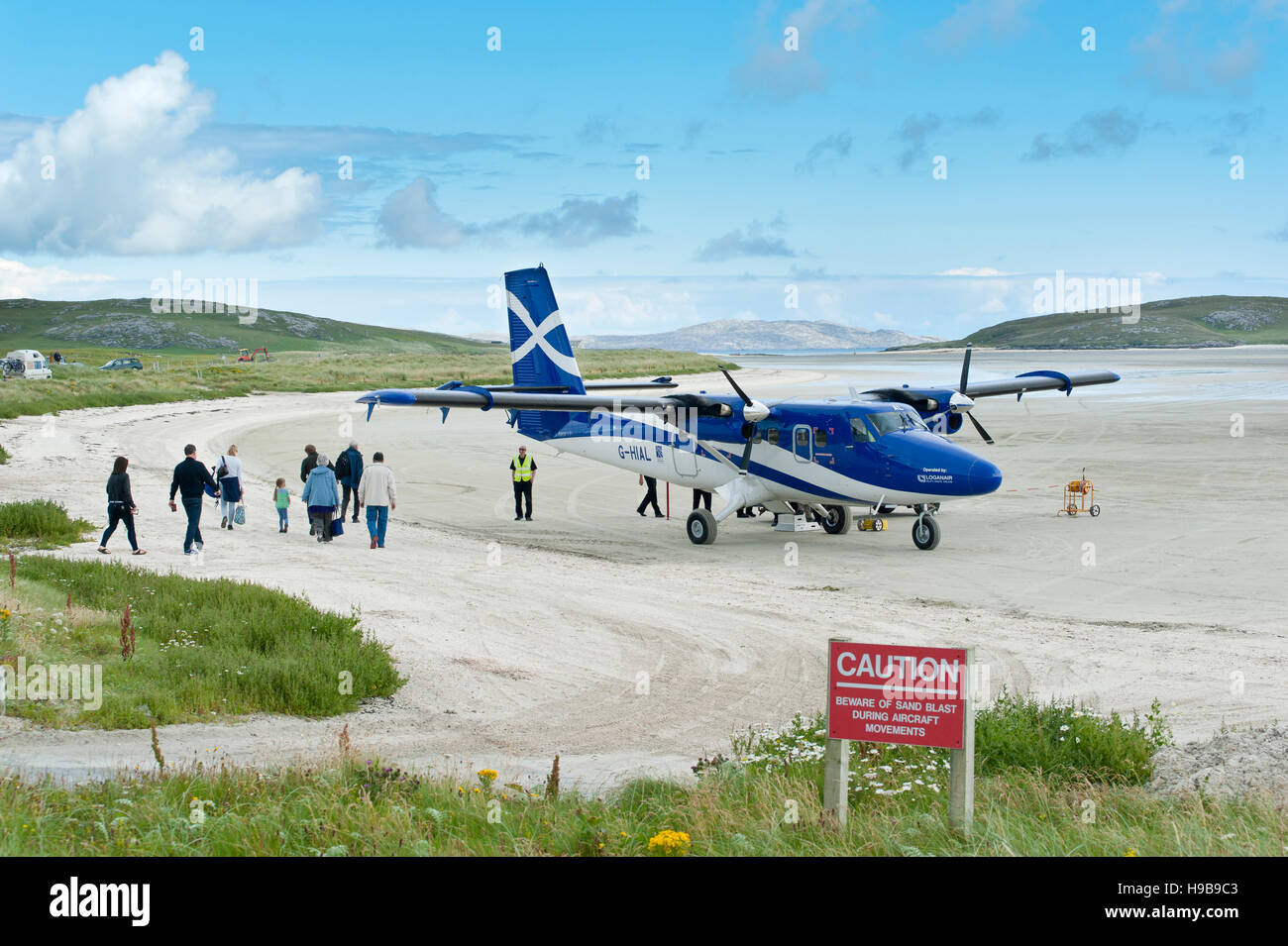 Flughafen und Flugzeug Twin Otter von schottischen Fluglinie Loganair, Passagiere beim boarding, Flugplatz am Sandstrand, Barra Airport Stockfoto