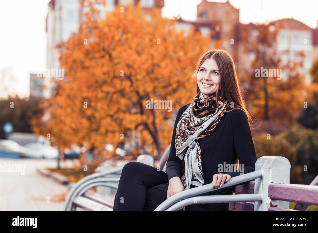 Junge Frau sitzt auf der Bank Stockfoto