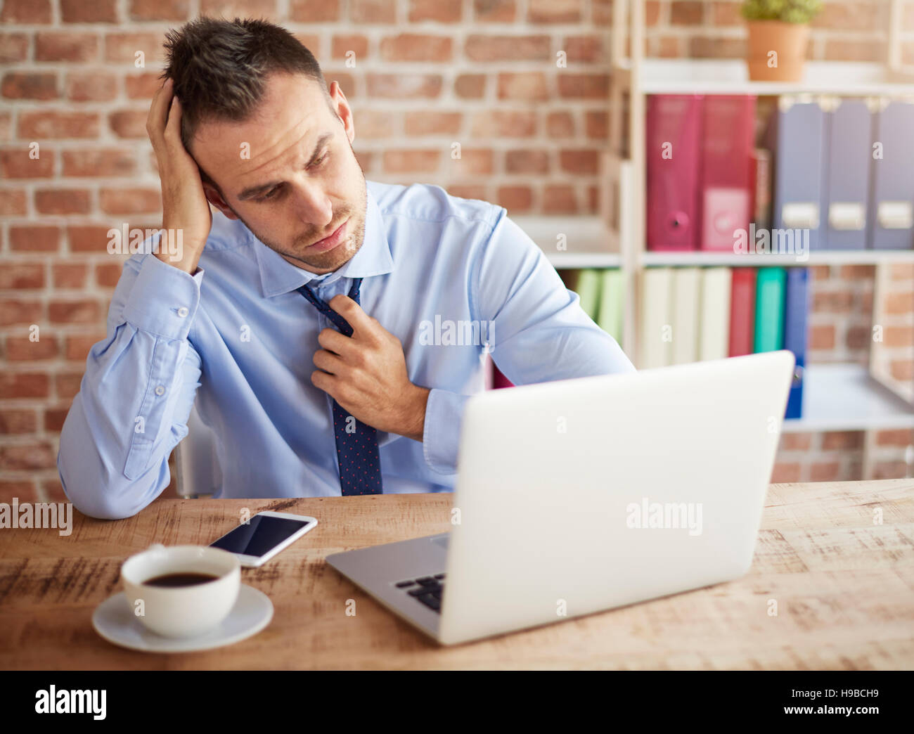 Mann und seine harten Aufgaben bei der Arbeit Stockfoto