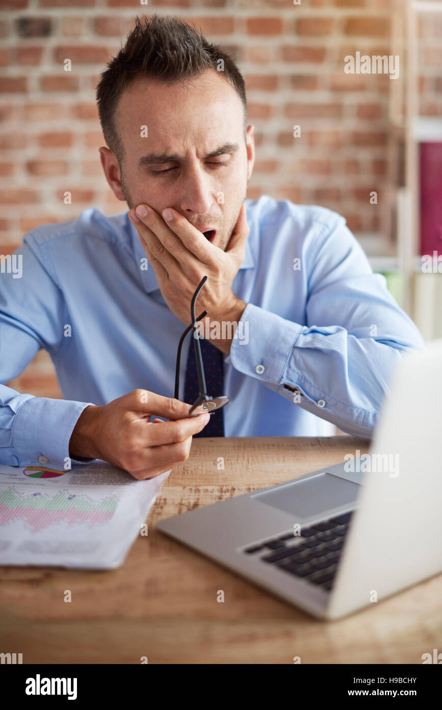 Mann über den Laptop Gähnen Stockfoto
