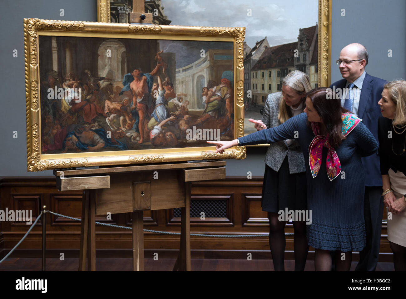 Generaldirektor der Staatlichen Kunstsammlungen Dresden, Marion Ackermann (L), der Vertreter der Geber, Darcy Bradbury (2.v.l.) und weitere Vertreter der Geber der Malerei-Studie "Massaker der unschuldigen" von Francesco Trevisani (ca. 1714, 75 x 136cm) über die Malerei zu sprechen, die auf einer Staffelei in der Gemäldegalerie Alte Meister in Dresden, Deutschland, 21. November 2016 steht. Die staatlichen Kunstsammlungen Dresden empfängt das Gemälde als Geschenk von privaten Eigentümern in New York. Die Öl-Studie ist die einzige bekannte malerische Studie, die die originale-Gemälde (250 x 464 cm) zeigt in seiner enti Stockfoto