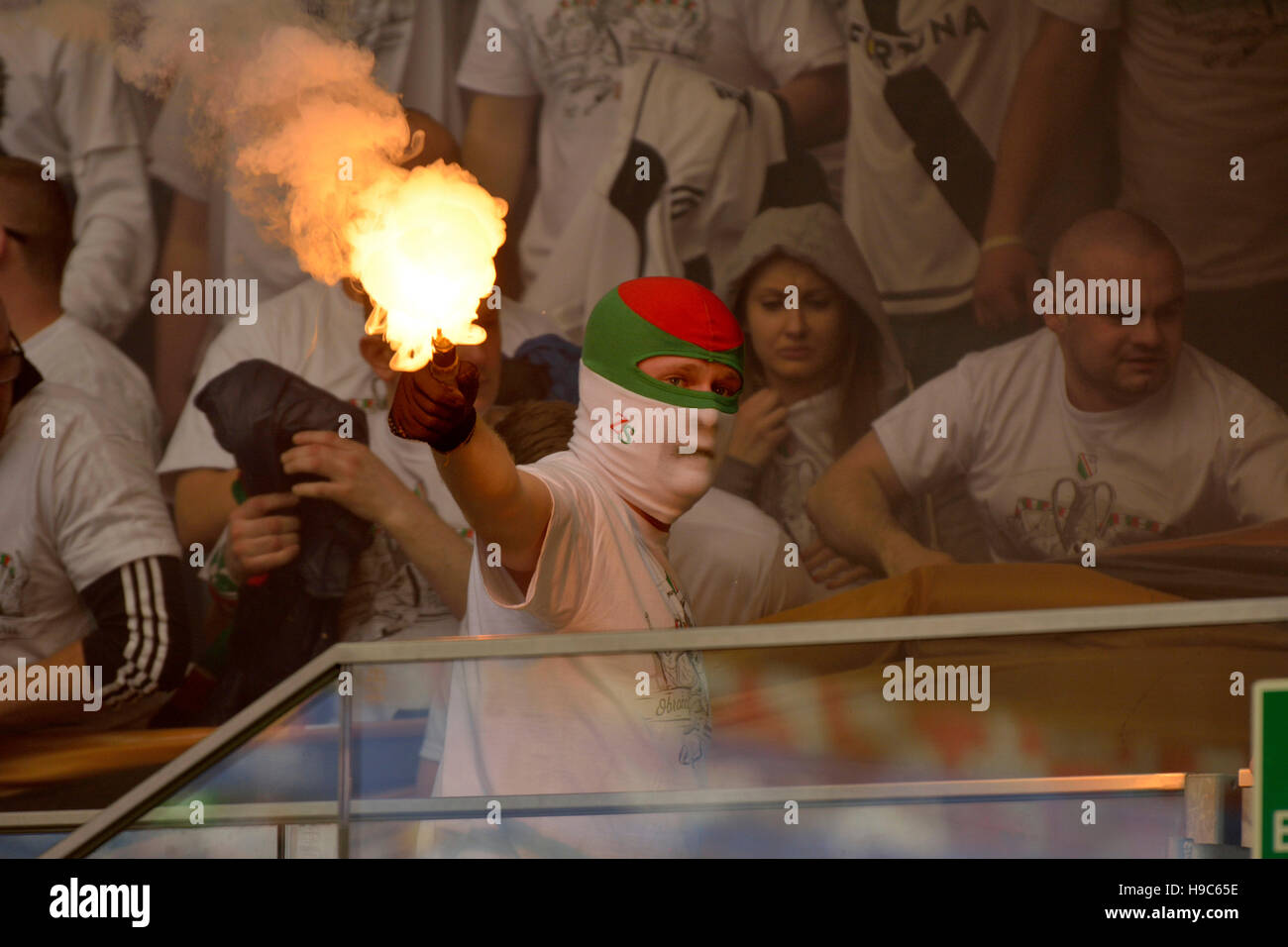 Legia Warsaw Ultras Fan Maske Halt Ein Brennendes Feuerwerk In Einer Rauchwolke Stockfotografie Alamy