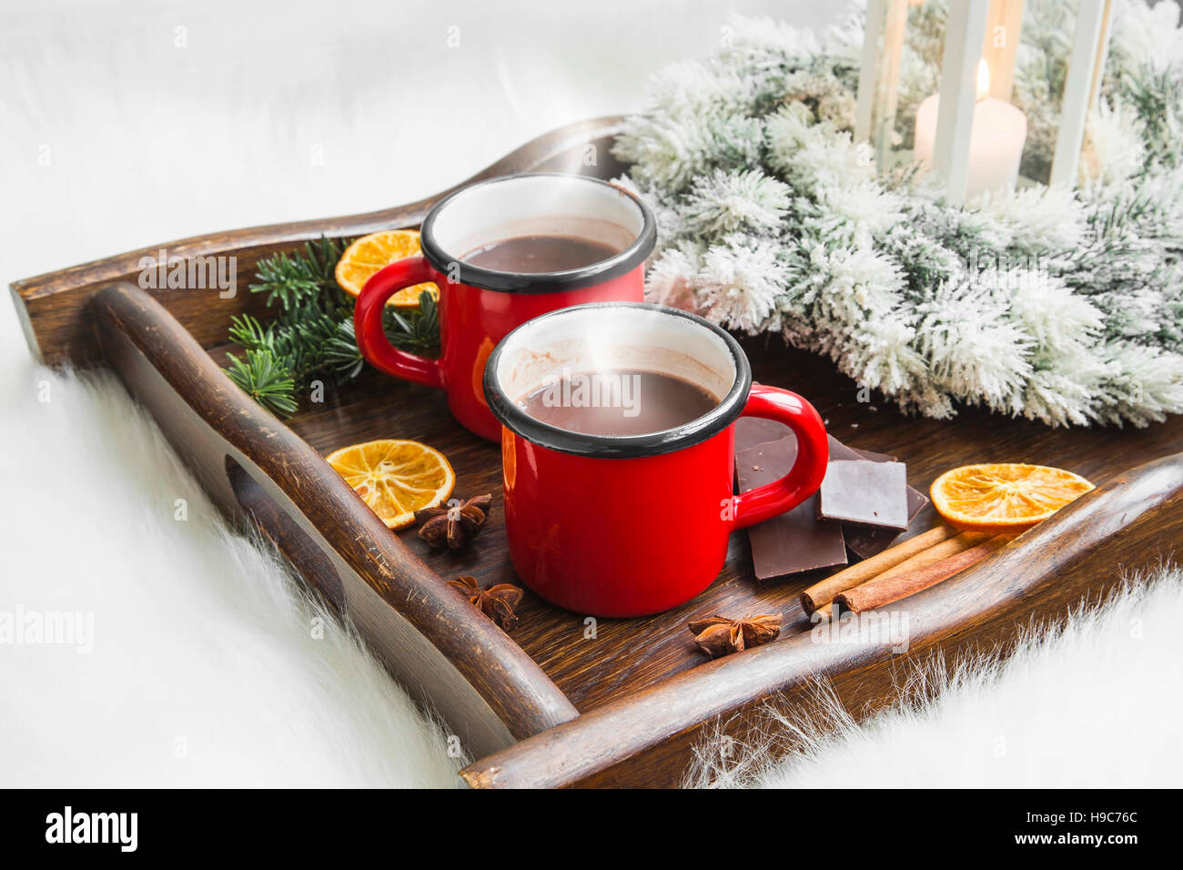 Winter heiße Schokolade Tassen mit Kerze Laterne und verschneiten Kranz, Gewürze winter Stockfoto