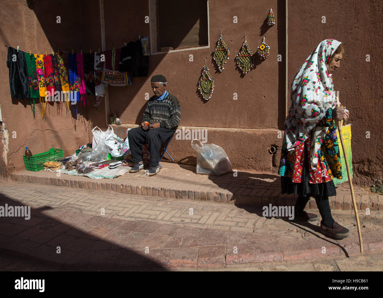 Iranerin tragen traditionelle Floreal Tschador und Mann mit Souvenirs für Touristen, Natanz Grafschaft, Abyāneh, Iran Stockfoto