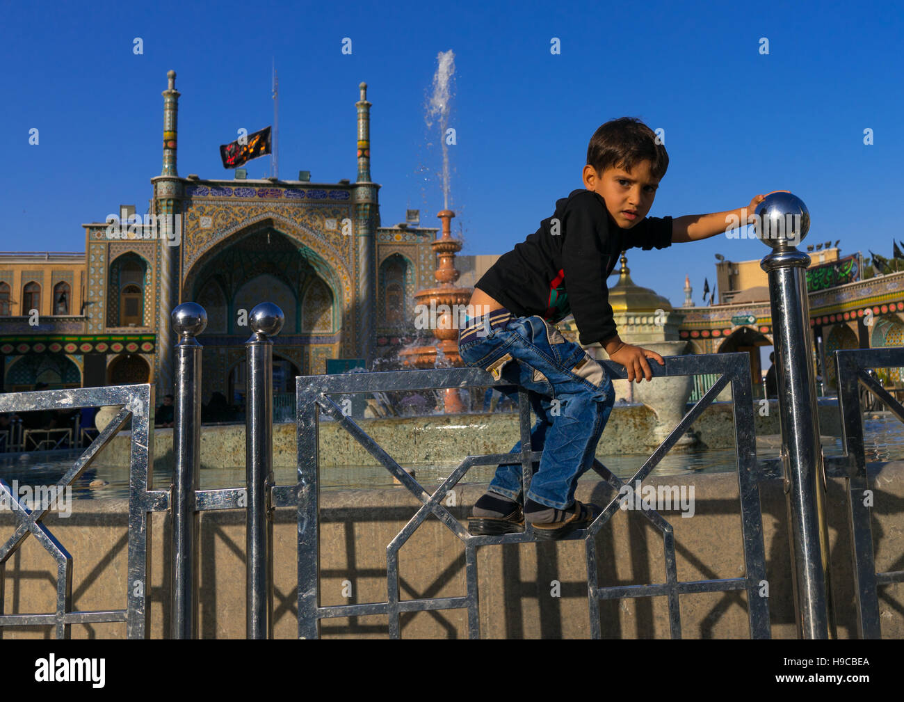 Junge, springen einen Zaun in Fatima al-Masumeh Schrein, zentrale Grafschaft, Qom, Iran Stockfoto