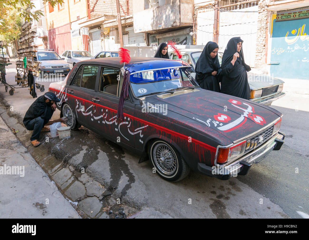 Ein Mann der schiitischen Iramian wäscht sein Auto dekoriert für Ashura Feiern zum Gedenken an den Jahrestag von Martyrium von Hussein, Lorestan Provinz, Khorrama Stockfoto