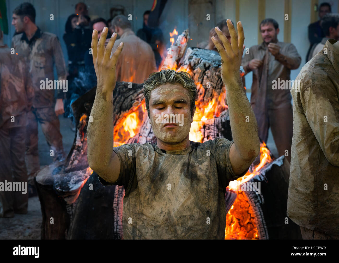 Iranische Schiiten muslimische Männer beten und versammeln sich um ein Lagerfeuer nach reiben Schlamm auf ihren Körper während des Kharrah Mali Rituals anlässlich den Aschura-Tag, Lo Stockfoto
