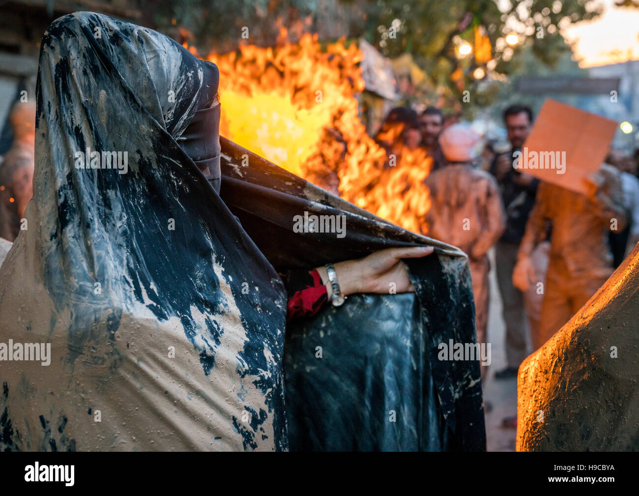 Iranische Schiiten muslimische Frauen versammeln sich um ein Lagerfeuer nach reiben Schlamm auf ihren Tschador während des Kharrah Mali Rituals anlässlich den Aschura-Tag, Lorestan Stockfoto