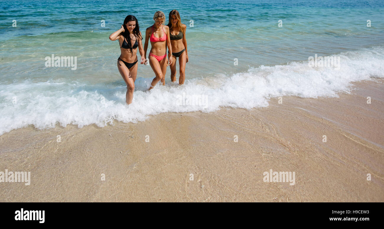 Aufnahme des jungen Freundinnen, die zu Fuß aus dem Meerwasser. Frau im Bikini zu Fuß am Ufer Meeres. Stockfoto