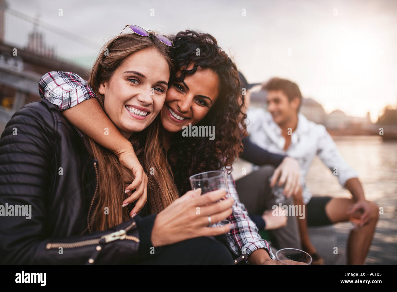 Aufnahme des jungen Freundinnen Spaß mit Getränken auf dem See. Gruppe von Personen, die einen Tag am See zu genießen. Stockfoto