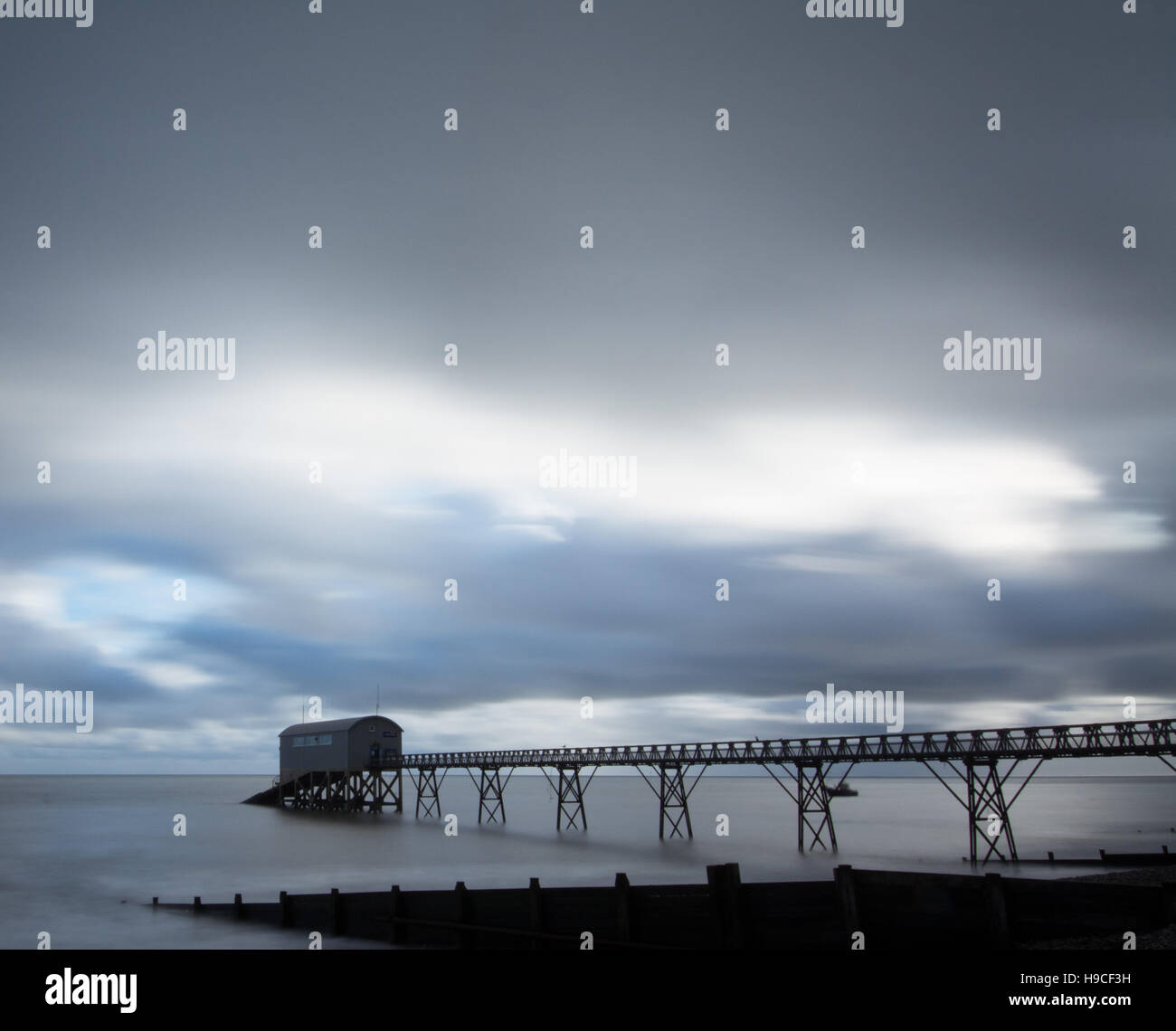 Lange Exposition von Selsey Rettungsboot Station in West Sussex, UK, mit dramatischen Himmel. Moody abstrakt. Stockfoto