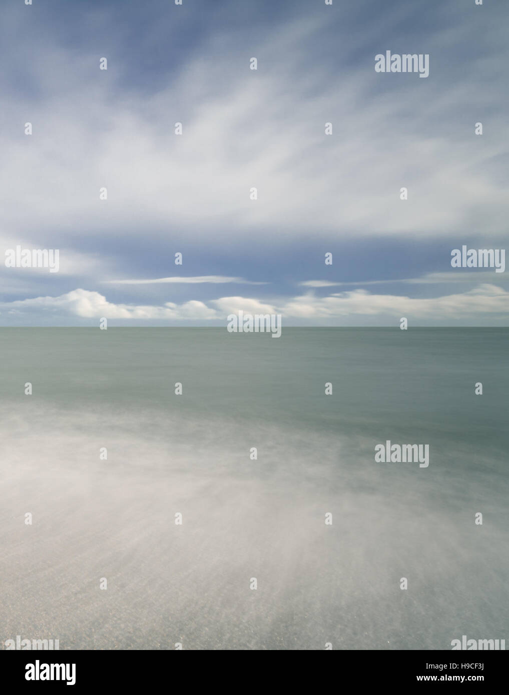 Lange Exposition von Selsey Strand in West Sussex, England, mit dramatischen Himmel. Moody abstrakt. Stockfoto