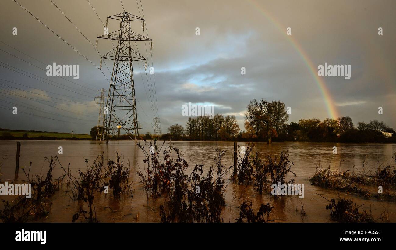 Ein Regenbogen bildet oben überschwemmten Feldern neben Station Road, Broadclyst, Devon, wo Flüsse traten über die Ufer und die wichtigsten Straßen südlich des Dorfes geschlossen. Stockfoto