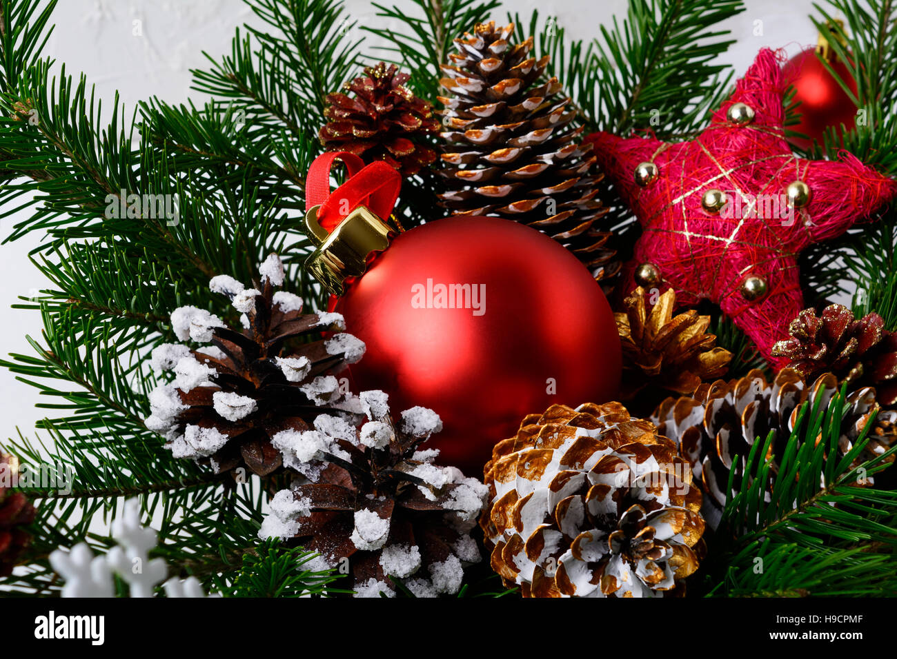 Christbaumschmuck rot und golden verzierten Tannenzapfen. Weihnachten Gruß Hintergrund. Stockfoto
