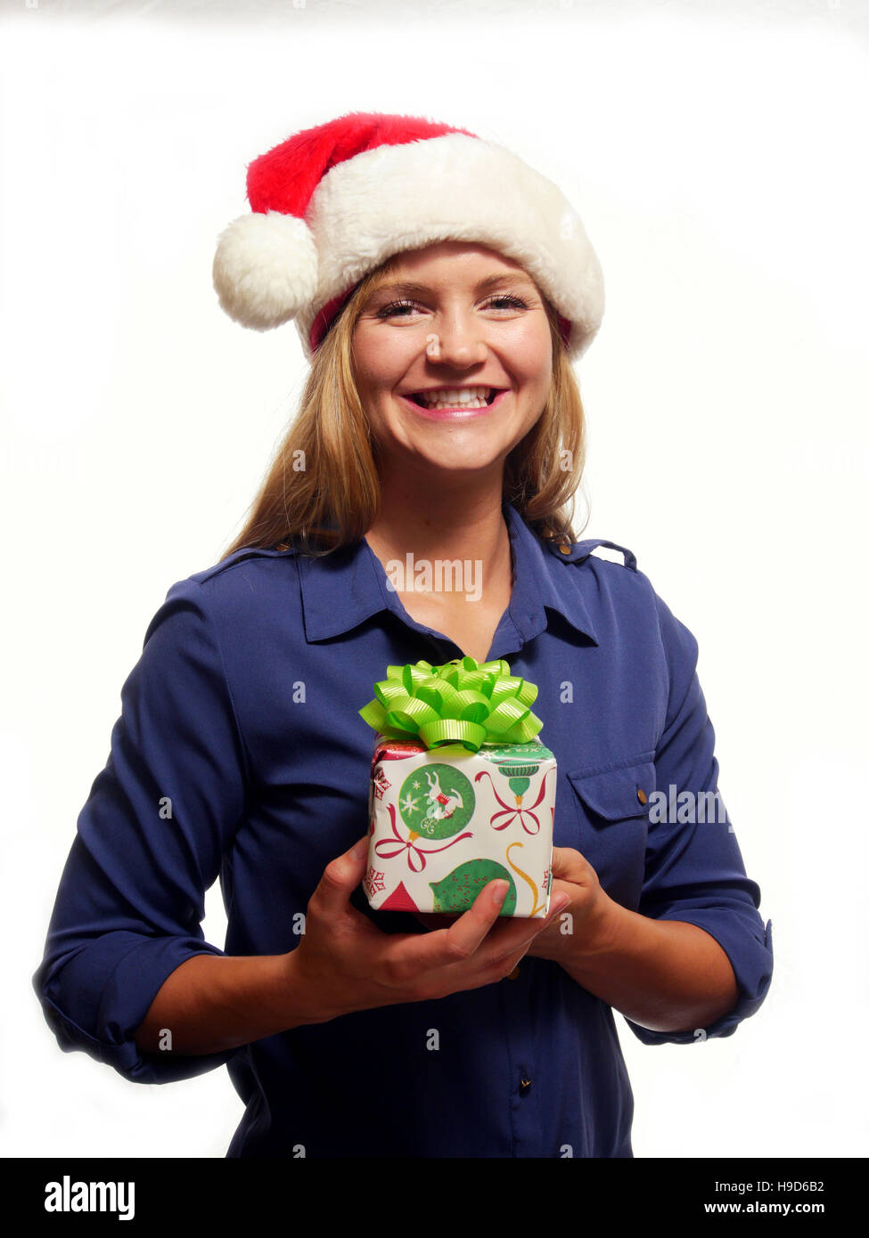 Eine attraktive Frau hält ein Weihnachtsgeschenk und lächelnd Stockfoto