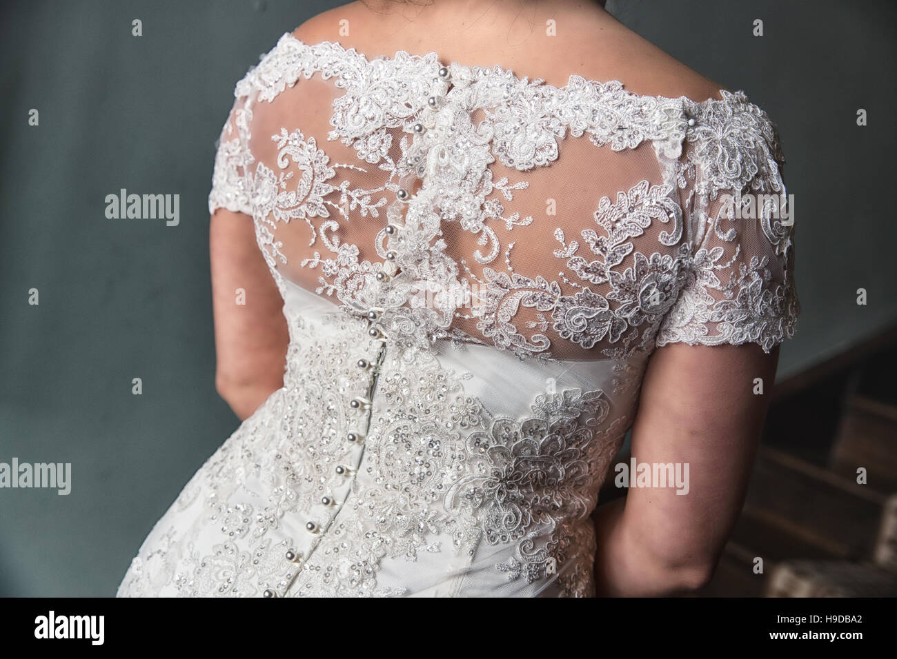 Weißes Brautkleid mit eleganten Knöpfen und Spitzen Detail oben. Stockfoto
