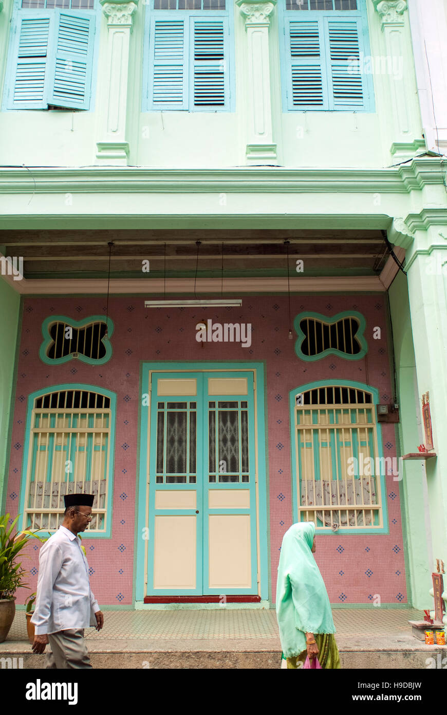 Eine ethnische Malaien paar Spaziergang vorbei an einer Meerenge chinesischen Terrasse Haus in Georgetown, Penang. Stockfoto